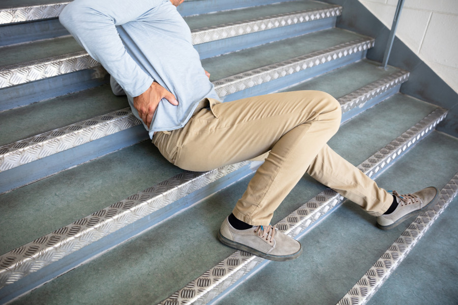 Man Lying On Staircase After Slip And Fall Accident